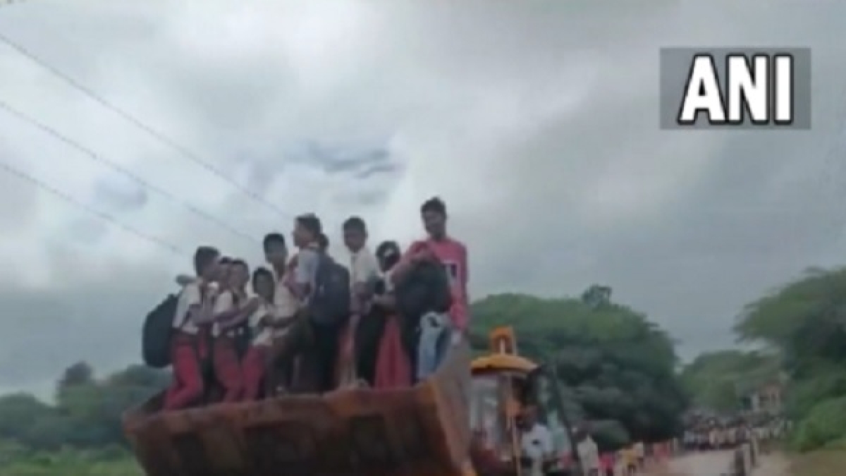 स्कूली बच्चे जेसीबी मशीन से पुल पार करते दिखे