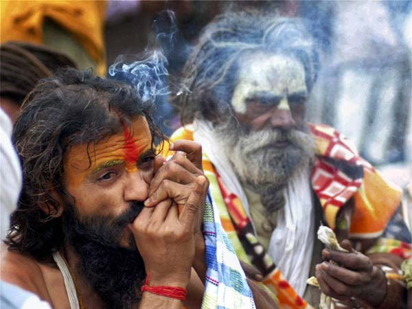 ठंड से बचने के लिए चिलम पीते साधु