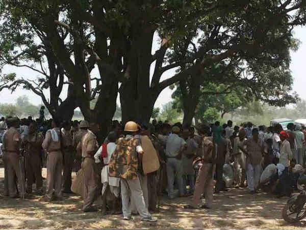 पेड़ से लटकी लाश को निहारती पुलिस
