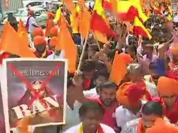 पोस्टर पर लाल रंग से क्रॉस बनाकर विरोध