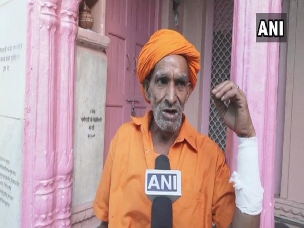पुजारी भक्तों को प्रसाद बांट रहा था