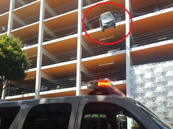 Driver accidentally hits accelerator, car hangs from the fourth floor of the multi-level parking Driver accidentally hits accelerator, car hangs from the fourth floor of the multi-level parking