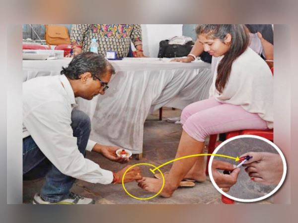 handicap girl without hands cast her vote, polling staff mark ink on foot handicap girl without hands cast her vote, polling staff mark ink on foot