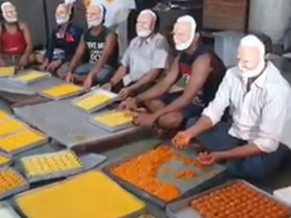 sweet shop workers Wearing a Modi mask during made sweet sweet shop workers Wearing a Modi mask during made sweet