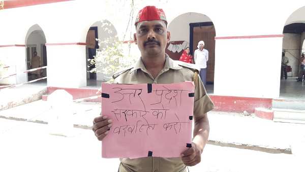 UP Police Constable Reaches to DM office with banner-Do Sack the UP government UP Police Constable Reaches to DM office with banner-Do Sack the UP government