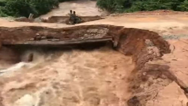 Terrifying moment motorcyclist and passenger plunge into flash flood after bridge collapses in Cambodia. Terrifying moment motorcyclist and passenger plunge into flash flood after bridge collapses in Cambodia.