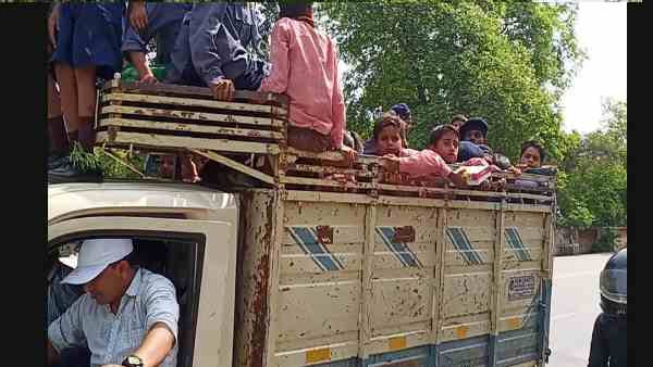 लोडर के ऊपर बैठे हैं बच्चे