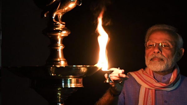 PM Narendra Modi lights a lamp after turning off all lights at his residence PM Narendra Modi lights a lamp after turning off all lights at his residence
