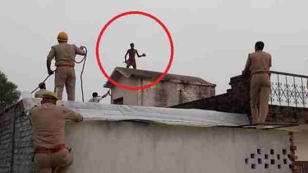 चार मंजिला मकान की छत पर चढ़ा शख्स