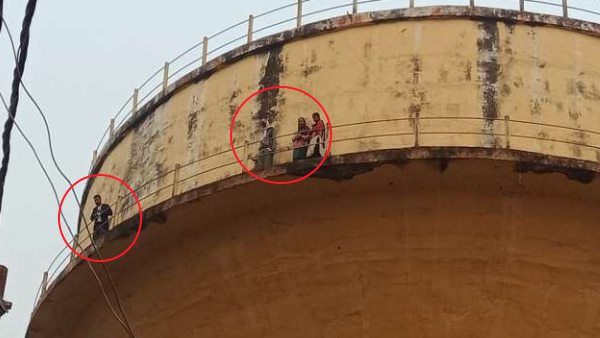 WATCH man climbs on water tank with his family threatening to self immolation in prayagraj WATCH man climbs on water tank with his family threatening to self immolation in prayagraj