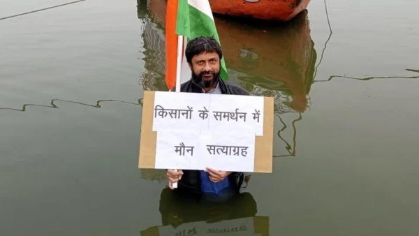 Youth with national flag did satyagrah while standing in Ganga in support of farmers Youth with national flag did satyagrah while standing in Ganga in support of farmers