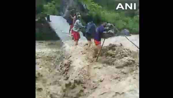 heavy rainfall in Dehradun: people trying to cross Amlawa River via a temporary bridge heavy rainfall in Dehradun: people trying to cross Amlawa River via a temporary bridge