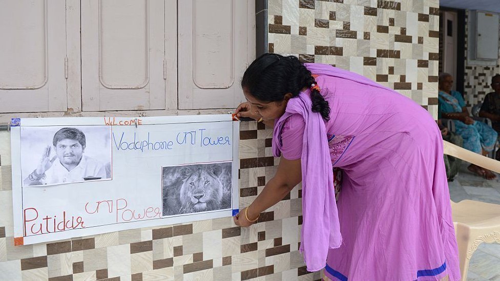 हार्दिक के घर उनके नाम का पोस्टर लगाती उनके परिवार की महिला (फ़ाइल फ़ोटो) हार्दिक के घर उनके नाम का पोस्टर लगाती उनके परिवार की महिला (फ़ाइल फ़ोटो)