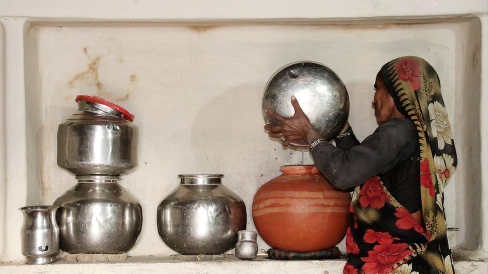महिला पानी भरते हुए महिला पानी भरते हुए