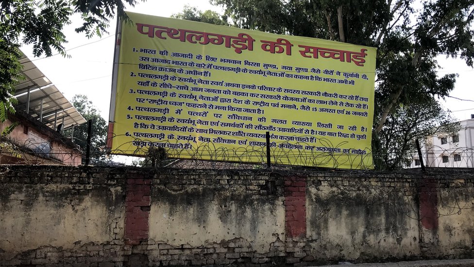 खूंटी थाना परिसर में आज भी ऐसा एक होर्डिंग लगा हुआ है लेकिन उस पर यह कहीं नहीं लिखा है कि उसे किसने लगवाया. खूंटी थाना परिसर में आज भी ऐसा एक होर्डिंग लगा हुआ है लेकिन उस पर यह कहीं नहीं लिखा है कि उसे किसने लगवाया.