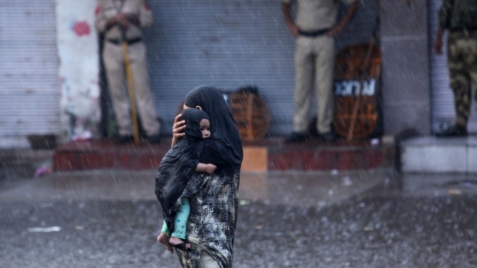 जम्मू में बारिश के दौरान महिला जम्मू में बारिश के दौरान महिला