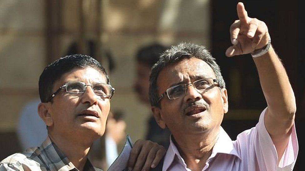 बाज़ार की चाल पर नज़र रखते दो व्यक्ति बाज़ार की चाल पर नज़र रखते दो व्यक्ति